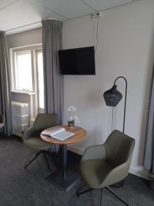 a room with a table and two chairs and a television at 't Streefkerkse Huis in Zoutelande