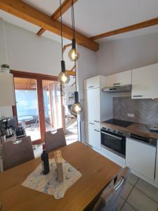 a kitchen with a wooden table and a dining room at Watt'n Traum in Butjadingen