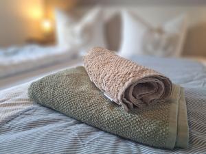 a rolled up towel sitting on top of a bed at Watt'n Traum in Butjadingen
