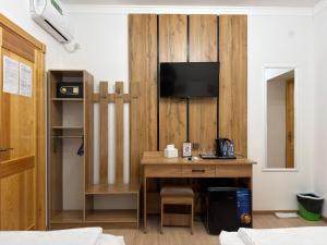 a room with a desk and a tv on a wall at Ulli Oy Boutique & Terrace in Khiva