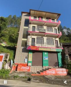 a building with cocacola signs on the side of it at Hotel Vivek Palace in Uttarkāshi