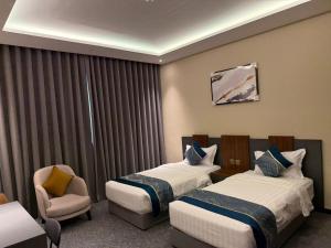 a hotel room with two beds and a chair at Belvedere Hotel in Medina