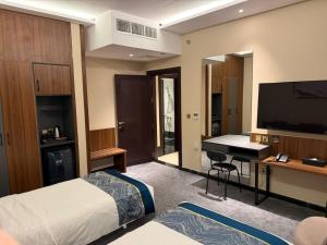 a hotel room with a bed and a desk and a television at Belvedere Hotel in Medina