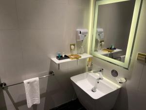 a white bathroom with a sink and a mirror at Belvedere Hotel in Medina
