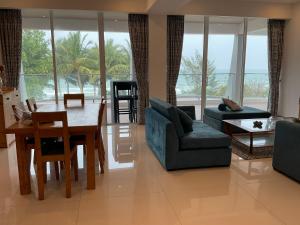 a living room with a table and a dining room at Royal Wave, Beachfront, Nilaveli in Trincomalee
