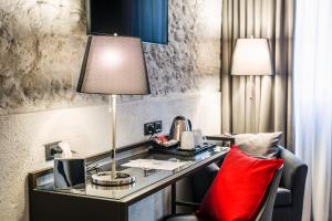 - un bureau dans une chambre d'hôtel avec un oreiller rouge dans l'établissement Locanda al Vescovo, à Vérone