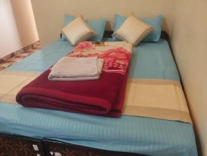 a bed with a red blanket on top of it at Hotel Vivek Palace in Uttarkāshi +7 photos