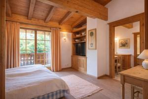 a bedroom with a bed and a large window at Chalet Lebenberg Kitzbühel in Kitzbühel