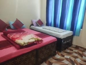 two twin beds in a room with blue curtains at Hotel Vivek Palace in Uttarkāshi