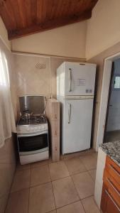 a kitchen with a stove and a white refrigerator at Hospedaje "LUZ" in Olavarría