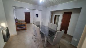 a dining room with a glass table and chairs at Hospedaje "LUZ" in Olavarría