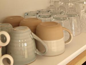 a shelf with glass jars and mugs on it at ILLU Resort in Orhei
