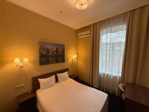 a hotel room with a bed and a window at Odeska Astoria in Odesa +63 photos