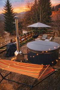 a hot tub with a table and chairs and an umbrella at Panoramic View Bran in Bran