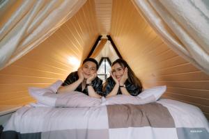 two girls laying on a bed in a tent at Inato Suites- Teepee House in Panglao Island