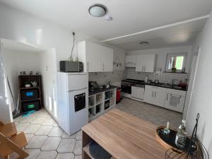 eine Küche mit weißen Schränken und einer Arbeitsplatte in der Unterkunft Wolke13 - gemütliche 2 Zimmer Wohnung mit voll ausgestatteter Küche in der City von Menden in Menden