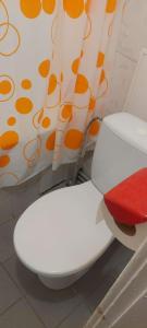 eine weiße Toilette in einem Badezimmer mit einem Vorhang in der Unterkunft Flat 2 rooms in Panevėžys