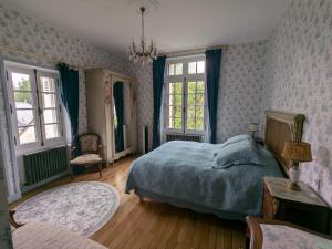 a bedroom with a bed and a table and windows at Castel Saint Laurent in Langeais