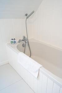 a bath tub with a faucet in a bathroom at Plockton Distillery Flat in Plockton +23 photos