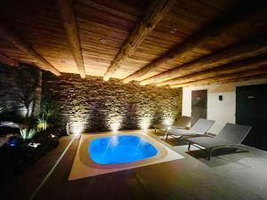 a living room with a large blue pool in a room at 10214 Chalet d'exception nature sport et bien être sauna,jacuzzi hammam frigidarium in Cervières +8 photos