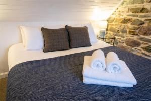 a bedroom with a bed with towels on it at Plockton Distillery Flat in Plockton