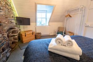 a bedroom with two towels on a bed at Plockton Distillery Flat in Plockton