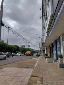 a city street with cars parked on the street at Kitnet no Centro Garagem, ar e Wi-Fi in Itaperuna
