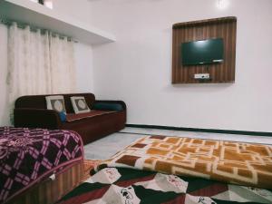 a living room with a couch and a flat screen tv at Laxmanji villas in Mount Ābu