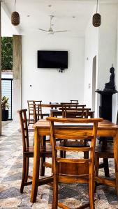 a dining room with a wooden table and chairs at Pearl Villa Katunayake in Katunayaka
