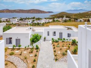 a view of a white villa with the sea in the background at Ammos Serifos in Serifos Chora
