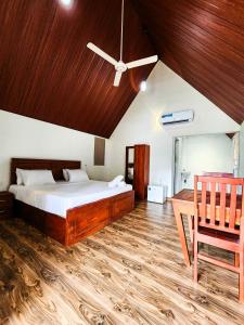 a bedroom with a bed and a wooden ceiling at Pearl Villa Katunayake in Katunayaka