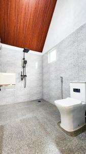 a bathroom with a toilet and a wooden ceiling at Pearl Villa Katunayake in Katunayaka +36 photos
