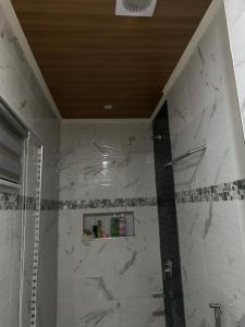 a bathroom with a shower with a marble wall at Shella Home Stay in Miagao +17 photos