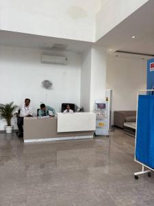 three people sitting at a counter in a room at The Pineapple Suite with Gorgeous Views in Greater Noida