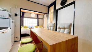 a kitchen with a desk and chairs in a room at 紡ぎの宿 桜 - 民泊 - Tsumugi no Yado SAKURA in Abiko