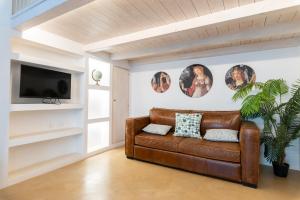 a living room with a brown leather couch at Suite Diffuse - Widespread Suite Collection PCB LUXURY in Ostuni