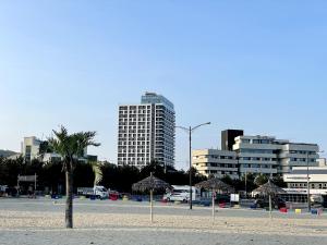 a beach with umbrellas and buildings in a city at 서프리조트 양양 빅웨이브 in Yangyang