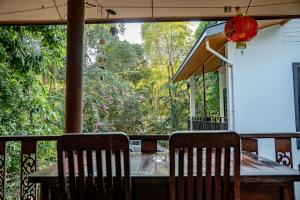 a table and chairs on a porch with a large window at Zen Rise in Ko Phangan