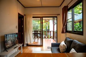 a living room with a couch and a tv at Zen Rise in Ko Phangan