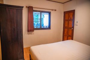 a bedroom with a bed and a window at Zen Rise in Ko Phangan
