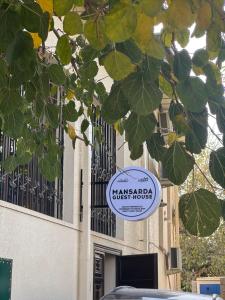 a sign for a guest house in front of a building at Mansarda hostel in Samarkand