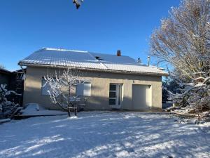 a house with a snow covered driveway in front of it at Le Cottage in Saint-Jean-de-Bournay