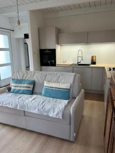 a living room with a couch and a kitchen at Le Cottage in Saint-Jean-de-Bournay