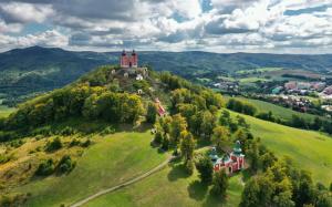 an old castle on top of a green hill at Apartmány v Müllerovom dome in Banská Štiavnica