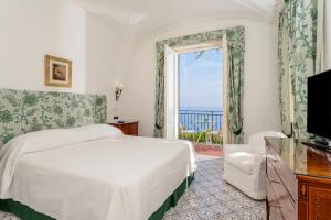 a bedroom with a bed and a sliding glass door at Hotel Santa Caterina in Amalfi