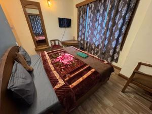 a bedroom with a bed with a flower on it at Hotel Taradavi Regency in Chhota Simla