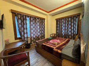 a bedroom with a bed and a chair and a window at Hotel Taradavi Regency in Chhota Simla