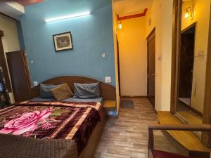 a bedroom with a bed in a room with blue walls at Hotel Taradavi Regency in Chhota Simla