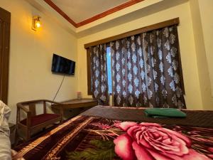 a bedroom with a bed with a curtain and a window at Hotel Taradavi Regency in Chhota Simla