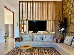 a living room with a couch and a flat screen tv at Villa Sun and Chill, Ferme d'hôtes familiale avec piscine animée, restaurant et jardin près de Safi in Safi